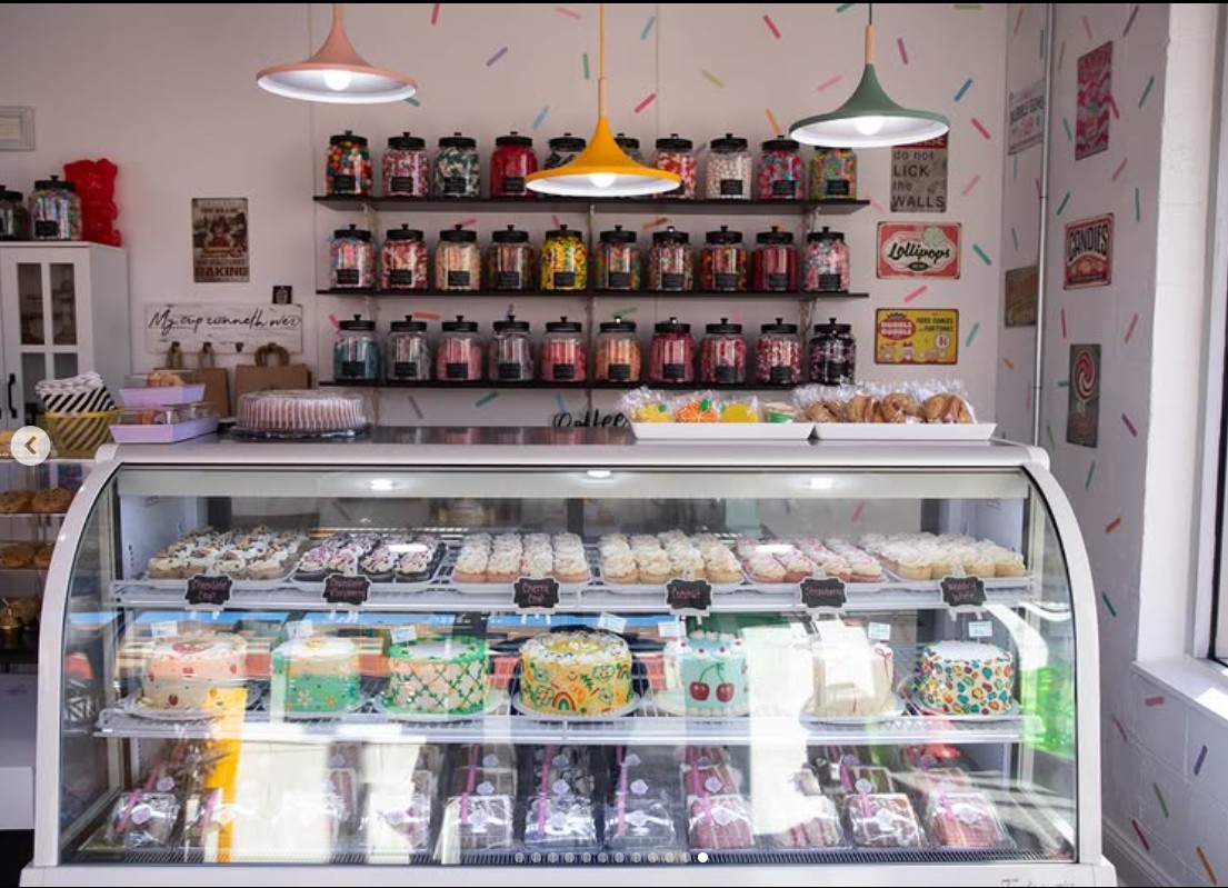 Bakery case with hand-painted cakes and pendant lights