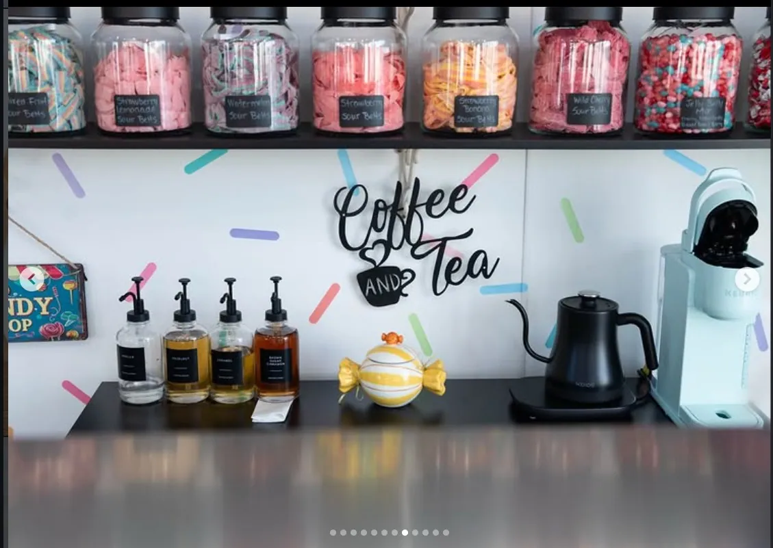 Coffee and tea station with hand-lettered sign and sour-belt candy jars